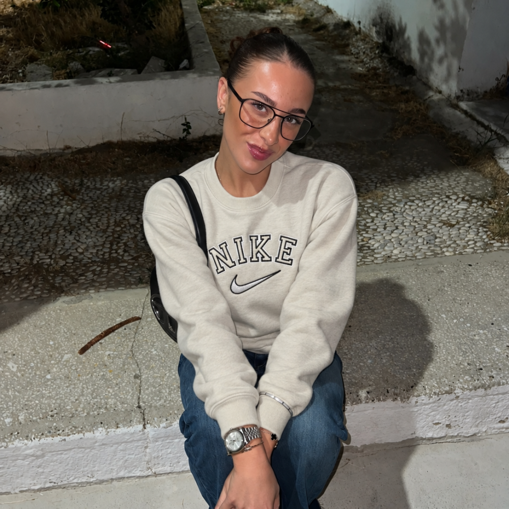 Cream crewneck with black and white Nike embroidery, worn with jeans
