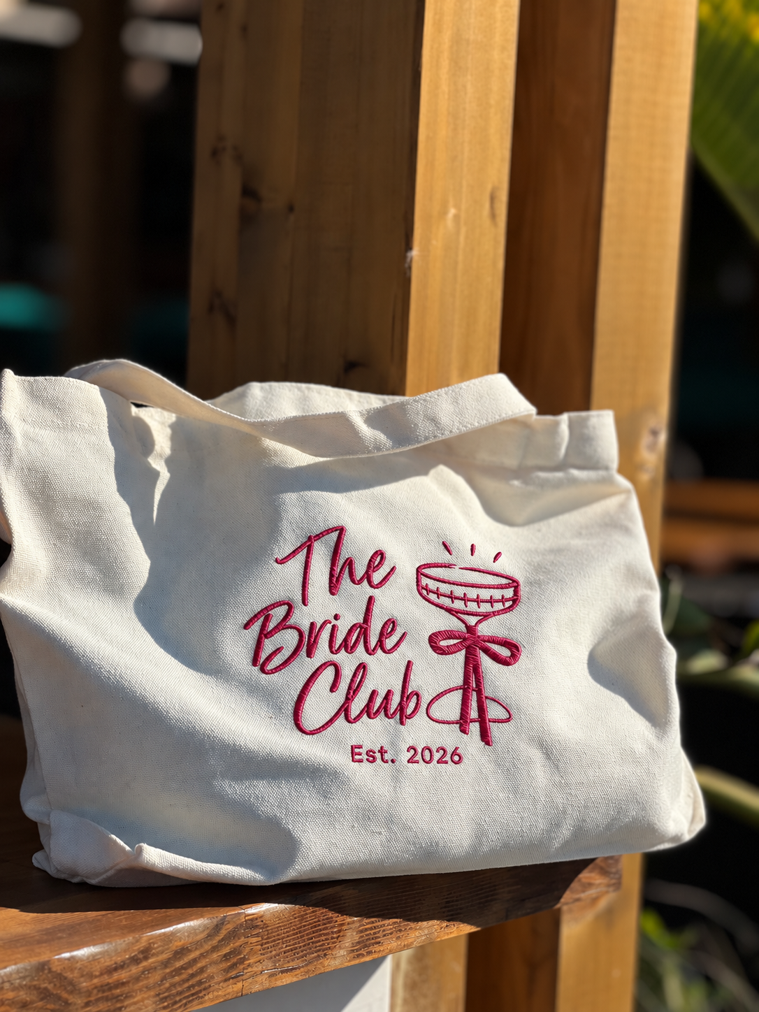 Cream Event Tote with raspberry embroidered The Bride Club design, champagne coupe and bow